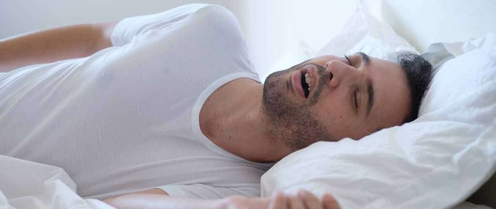 Person covering their mouth, illustrating the concept of mouth breathing and its impact.