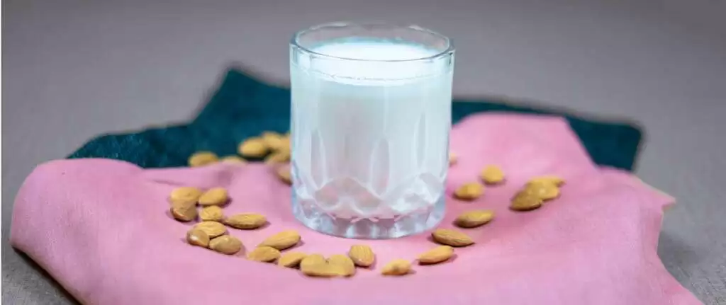 Almond milk in a glass with almonds, highlighting its health benefits and nutrition