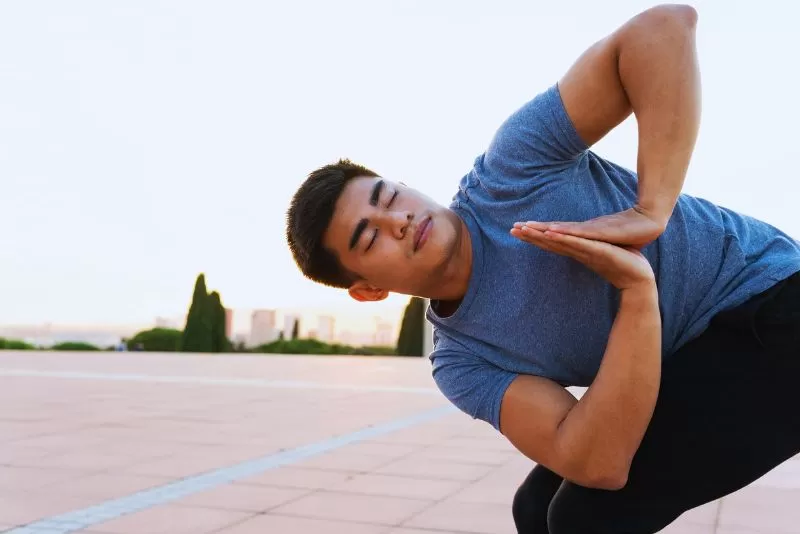 Woman practicing Twisted Chair Pose (Parivrtta Utkatasana) to enhance weight loss, core strength, and balance in a yoga session.